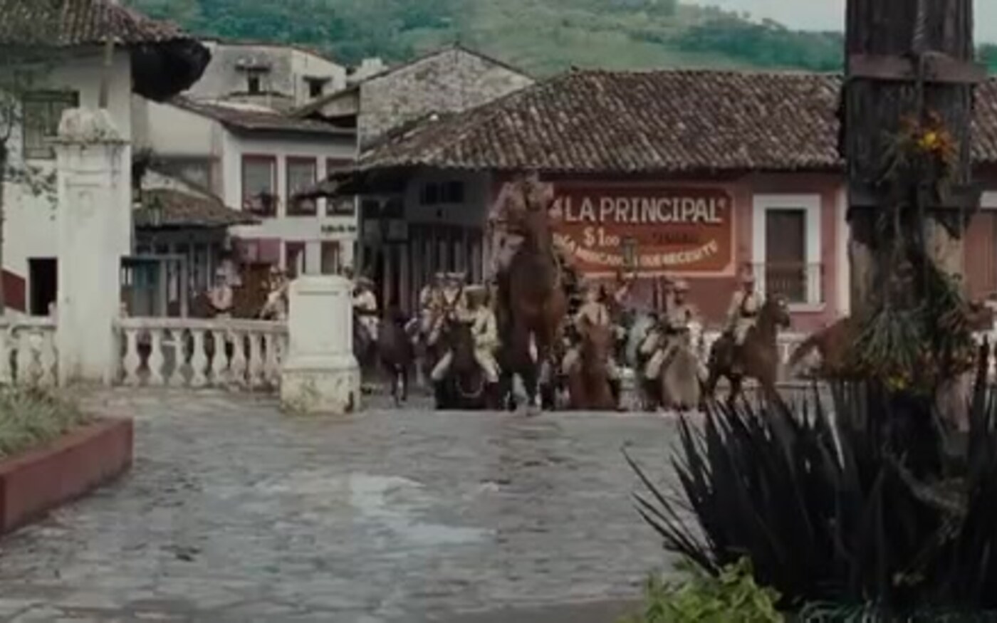 Horsemen in Cristero-era uniforms ride through a Mexican town square in For Greater Glory