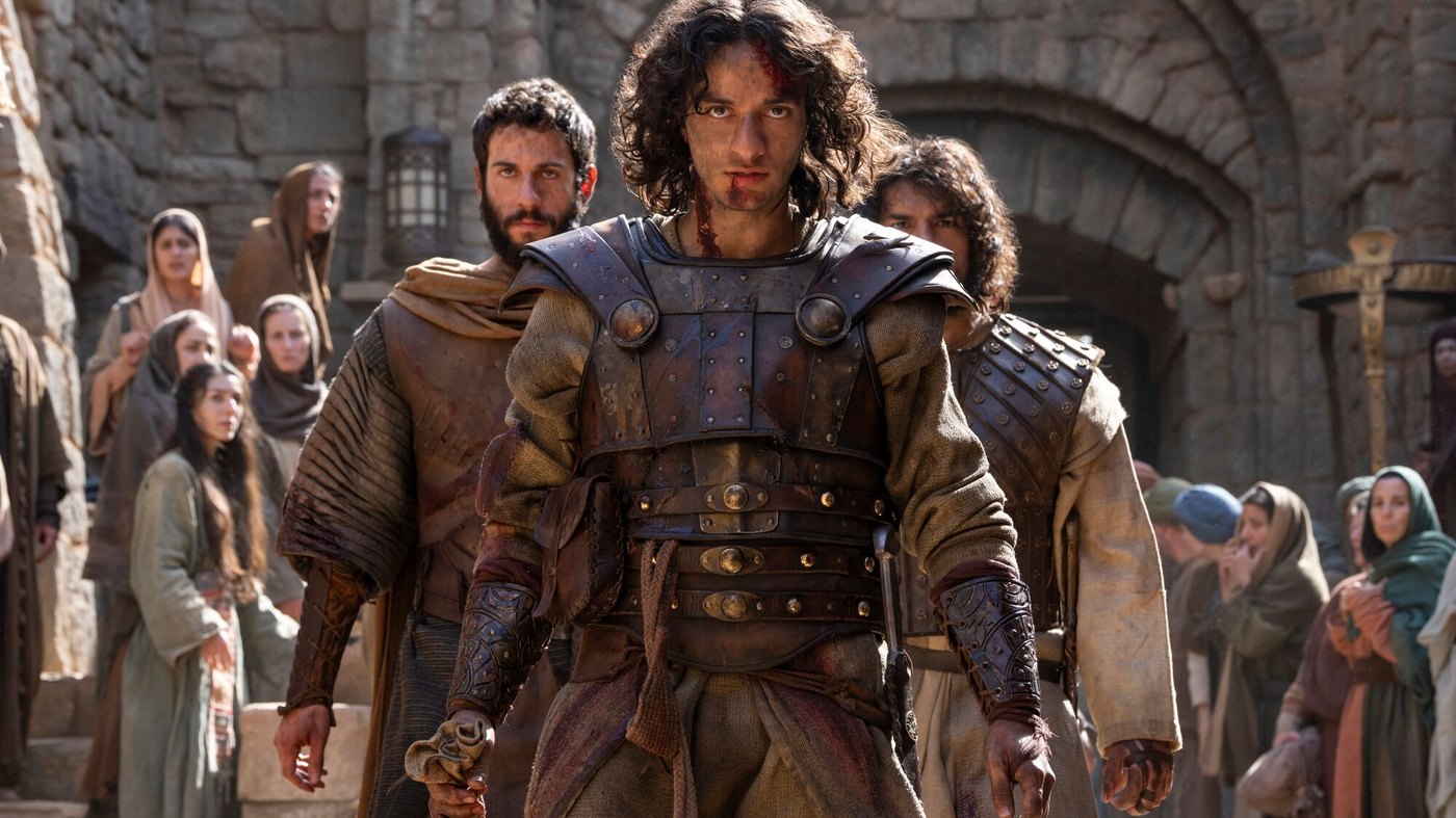 Michael Iskander as David in leather scale armor walking a stone courtyard with extras in House of David